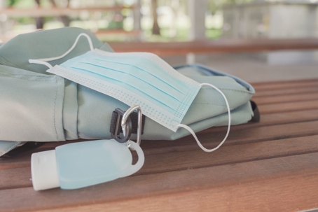 Student school bag with medical mask and hand sanitizer clip on